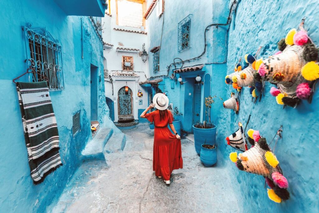 Travelers taking pictures at colorful Moroccan alleyway